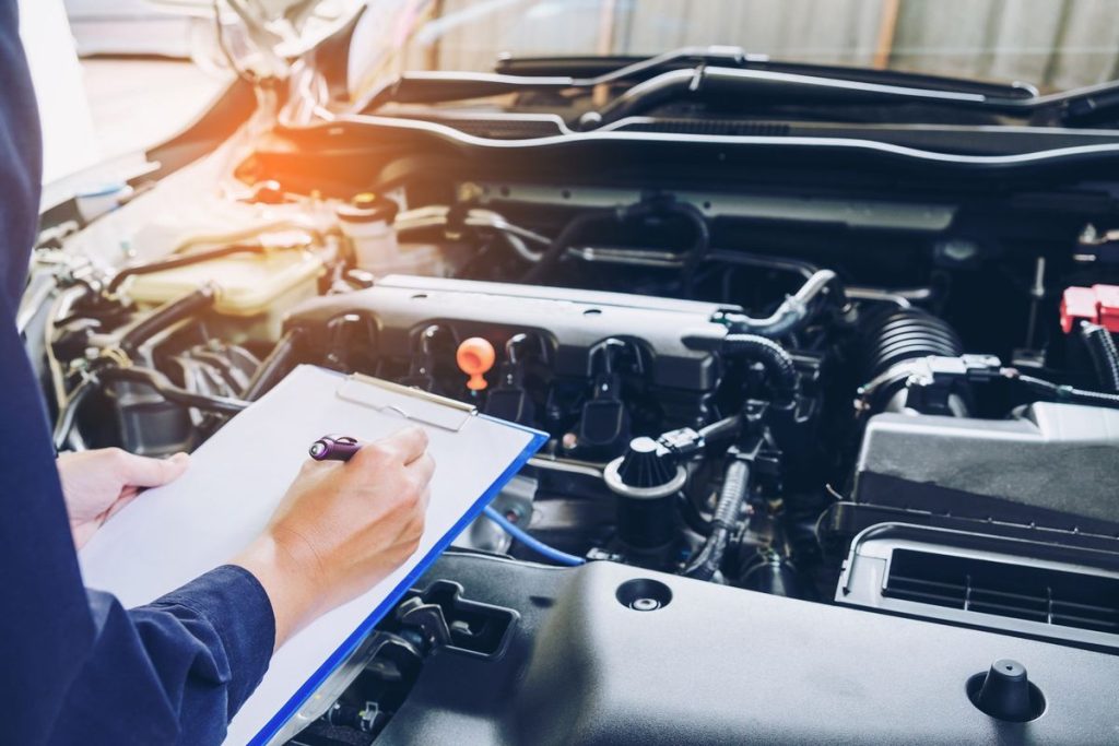 Mechanic servicing a petrol car at a local auto workshop, highlighting maintenance and inspection.